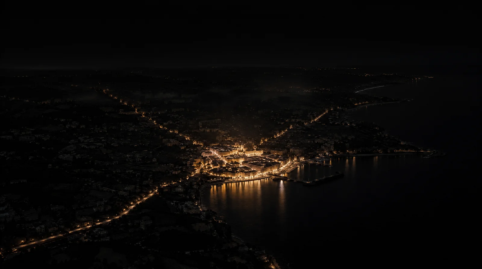 Illustration av organisk synlighet: ett upplyst kvarter i en mörk kuststad.